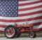 Farmall tractor in front of US flag.