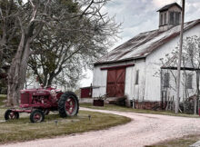 Farmall tractor and big white barn